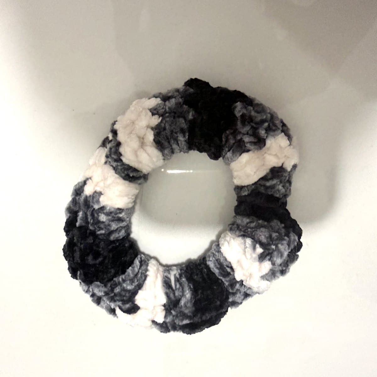 Striped black, charcoal and ivory crochet scrunchie, seen from above